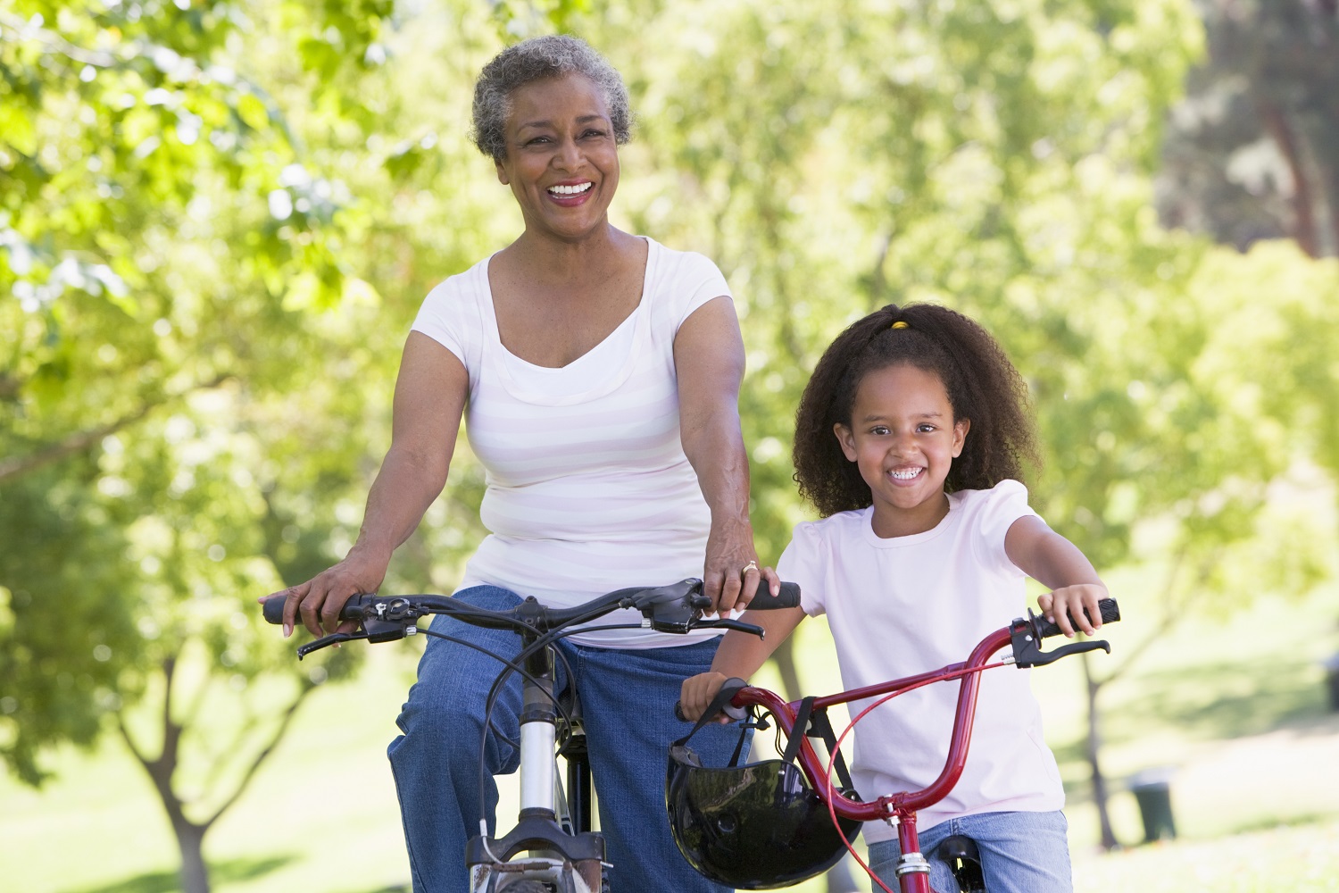 Abuela y nieta en bicicleta en el parque 