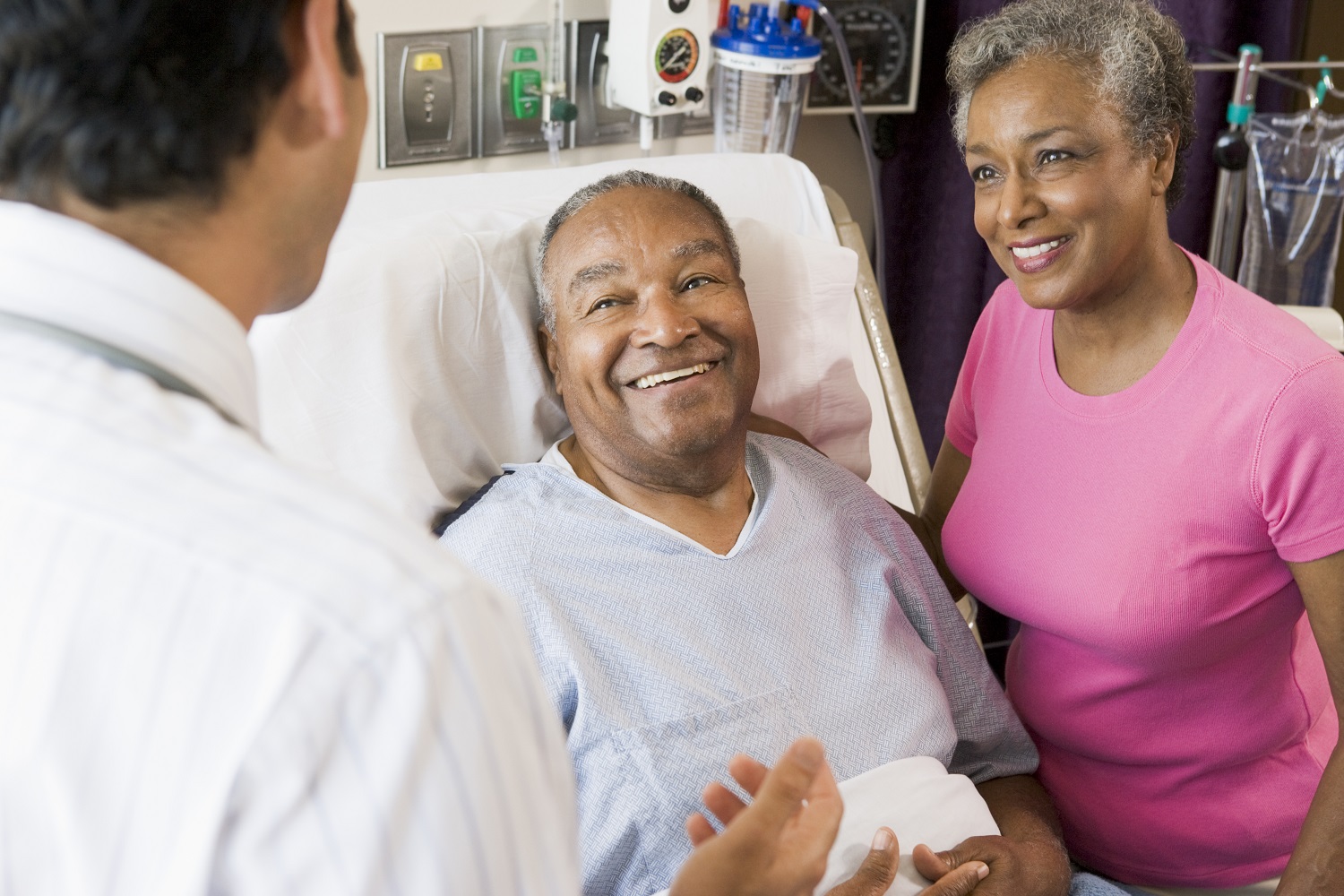 Médico conversando com um casal de pacientes sorridentes