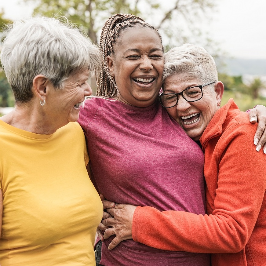 Tres amigas abrazándose y sonriendo