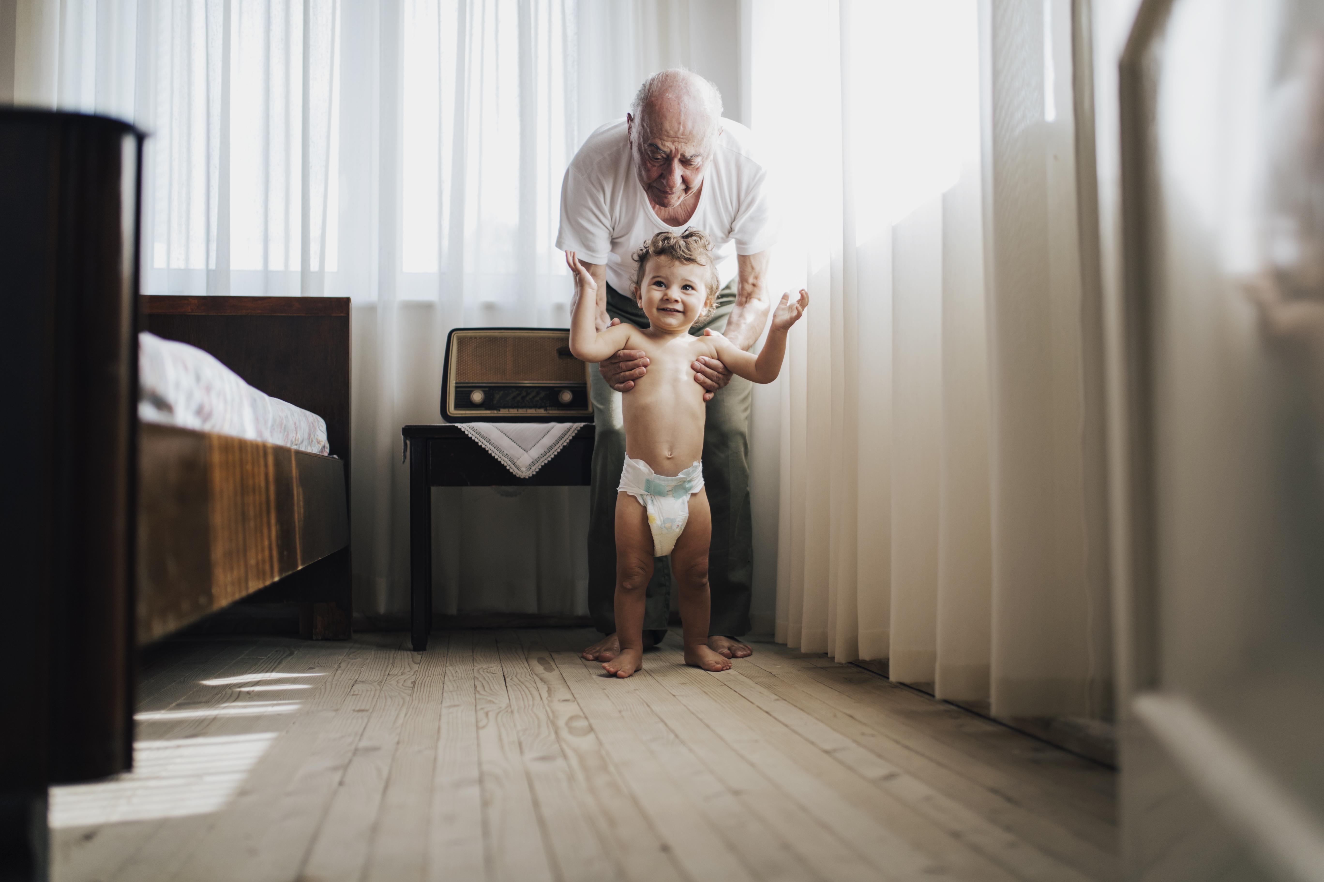 An AFib patient helps his grandson take his first steps. He is optimistic about his future after talking to an electrophysiologist (AFib Specialist) about Cardiac Catheter Ablation.